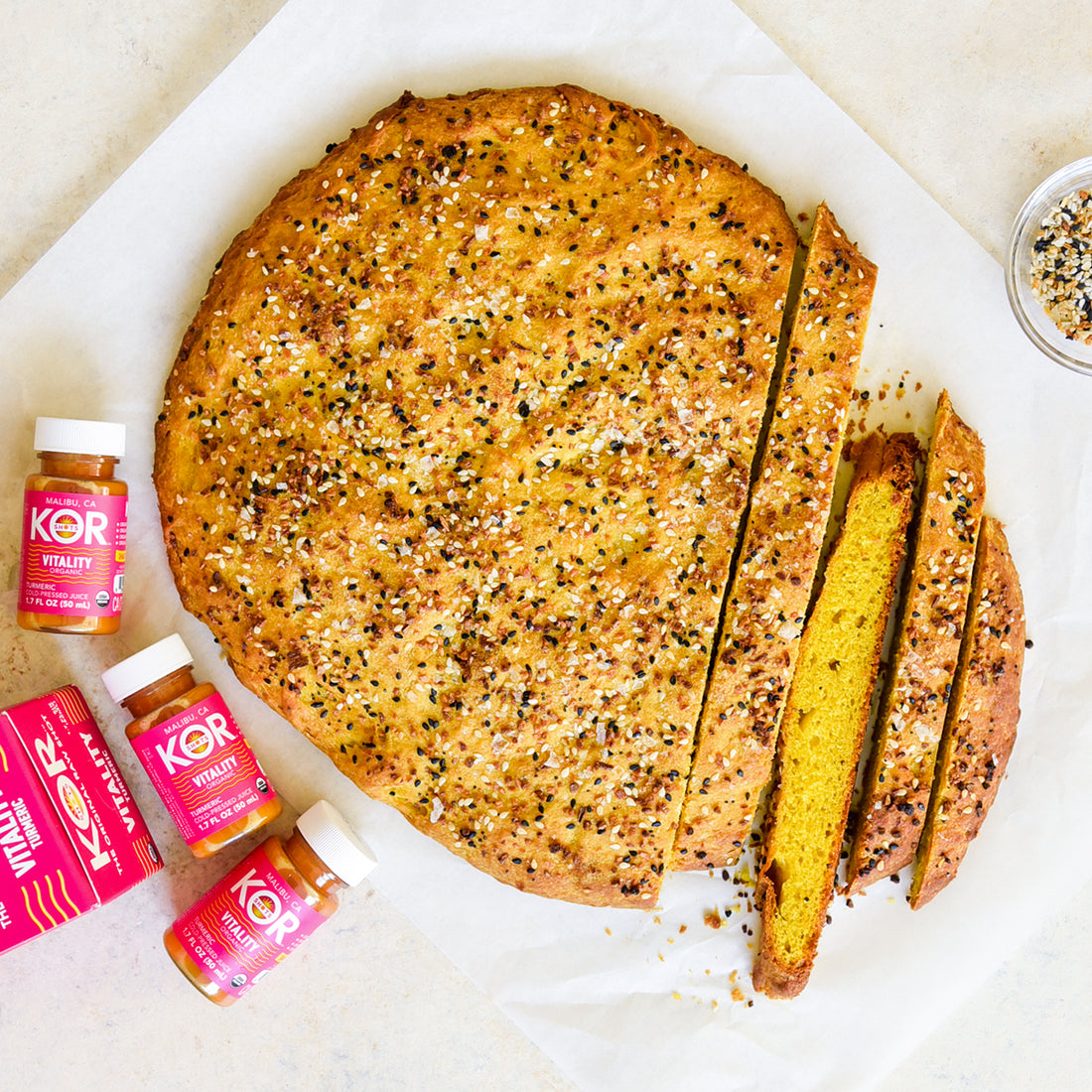 loaf of focaccia bread on white counter top with vitality kor shots