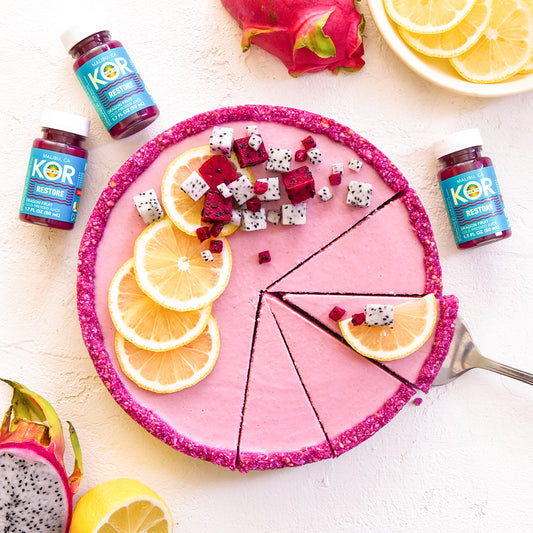 pink lemon tart with dragon fruit pieces and RESTORE on a white table