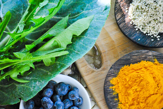 kale blueberries and turmeric on wooden chopping board