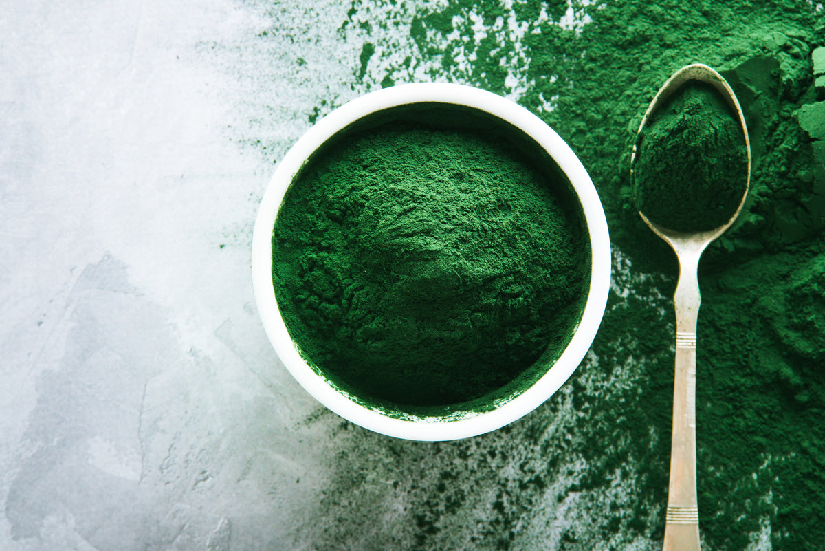 powdered spirulina on a white marble background